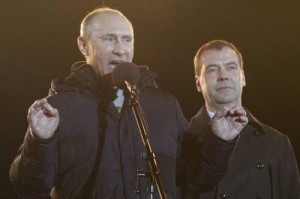 Russia's current PM Putin addresses supporters, while President Medvedev stands nearby, during a rally in Manezhnaya Square near the Kremlin in central Moscow
