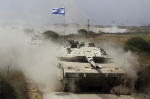 An Israeli soldier rides a tank after returning to Israel from Gaza