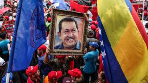 (160501) -- CARACAS, mayo 1, 2016 (Xinhua) -- Un hombre sostiene la imagen del fallecido presidente venezolano Hugo Chávez durante un evento para conmemorar el Día Internacional del Trabajo, en Caracas, Venezuela, el 1 de mayo de 2016. El presidente de Venezuela, Nicolás Maduro, anunció el domingo el aumento del salario mínimo de los trabajadores en un 30 por ciento, el cual entró en vigencia el domingo, a fin de garantizar los ingresos de los venezolanos "en tiempos de guerra económica". (Xinhua/Boris Vergara) (bv) (vf) (ah)